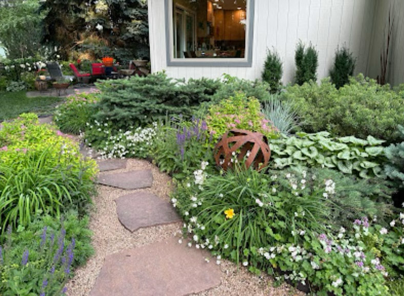 Gartenbetten neben Haus mit vielen Texturpflanzen